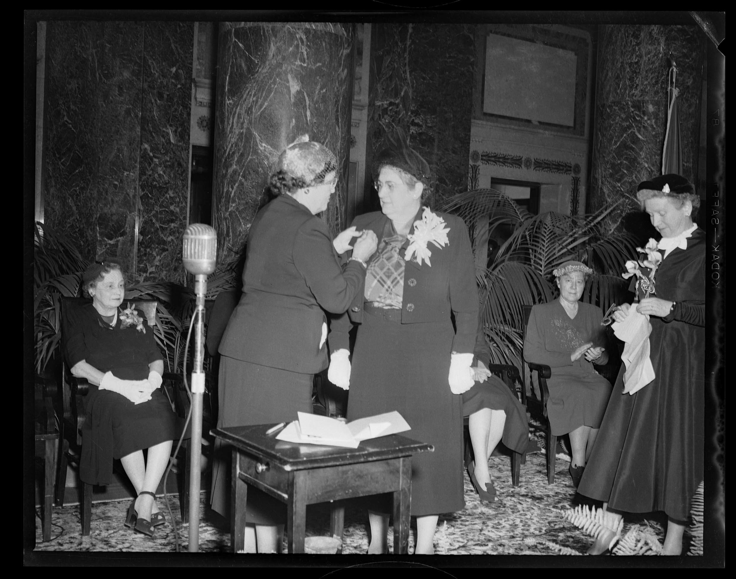 Event In Carnegie Music Hall Foyer Woman Placing Pin On Another