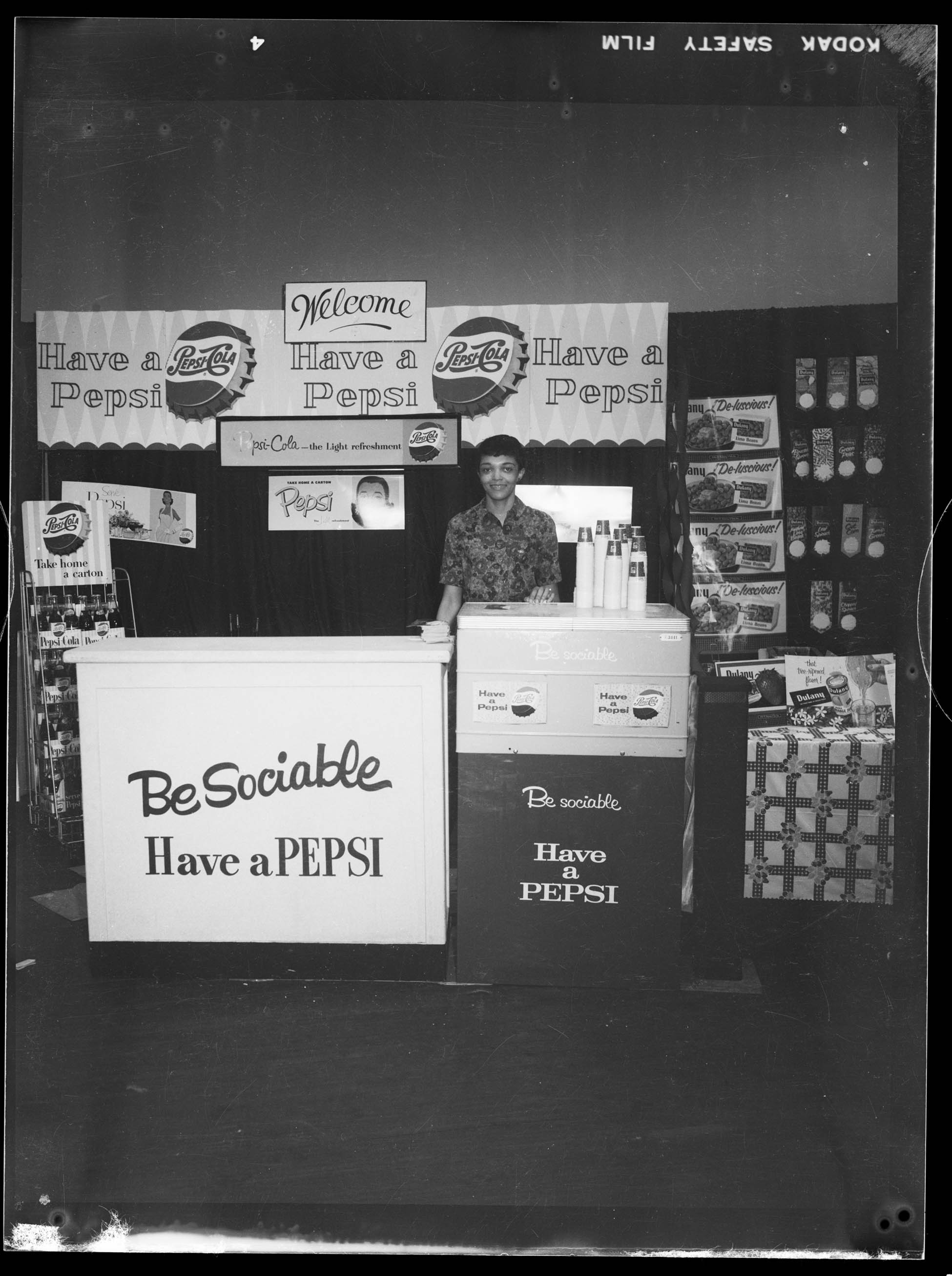 Jackie Perry posed in Metropolitan Bottling Company booth advertising