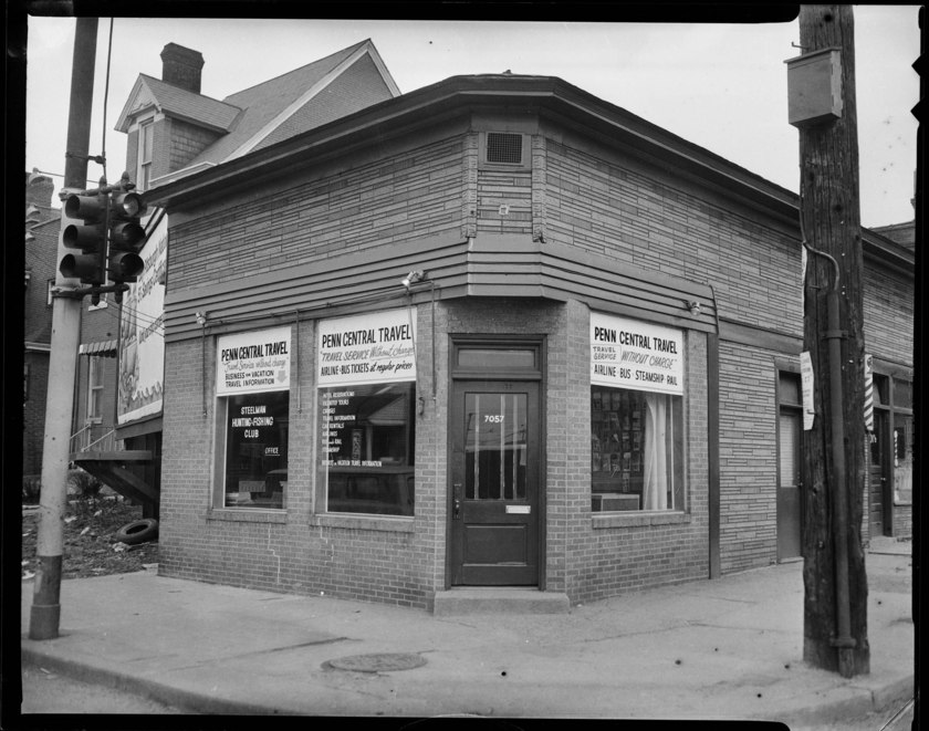 Exterior of Penn Central Travel office, with sign in window reading