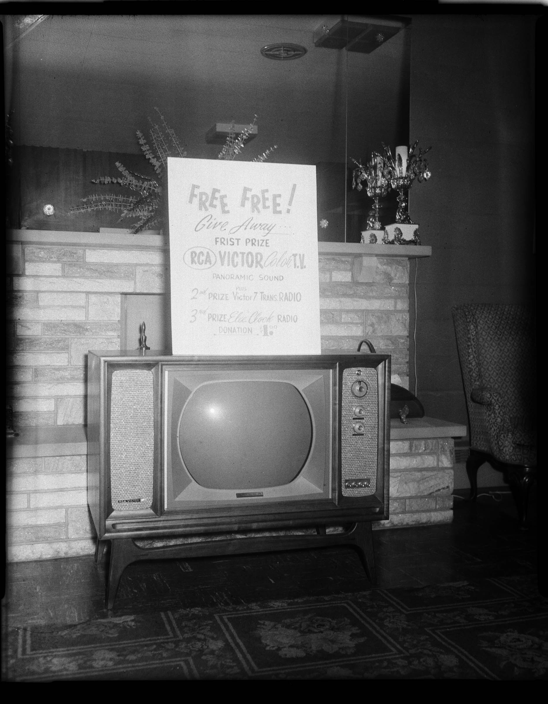 Television in showroom with sign reading “Free! Free! Give away first