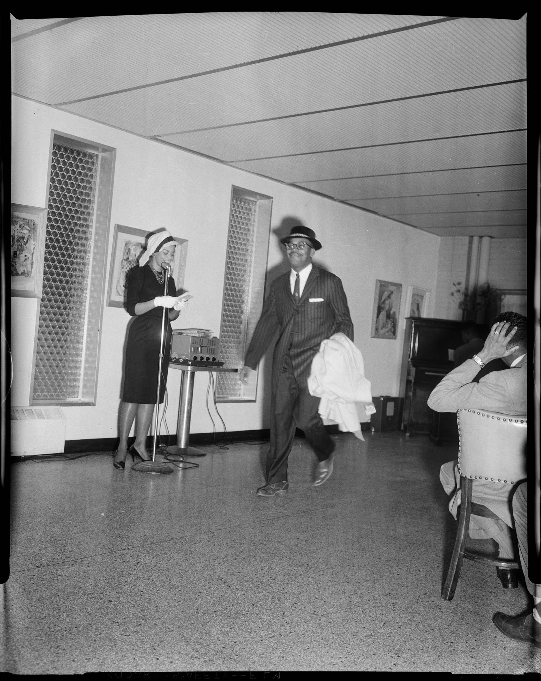 Man Wearing Pinstriped Suit And Hat With Coat In His Arm Walking In 