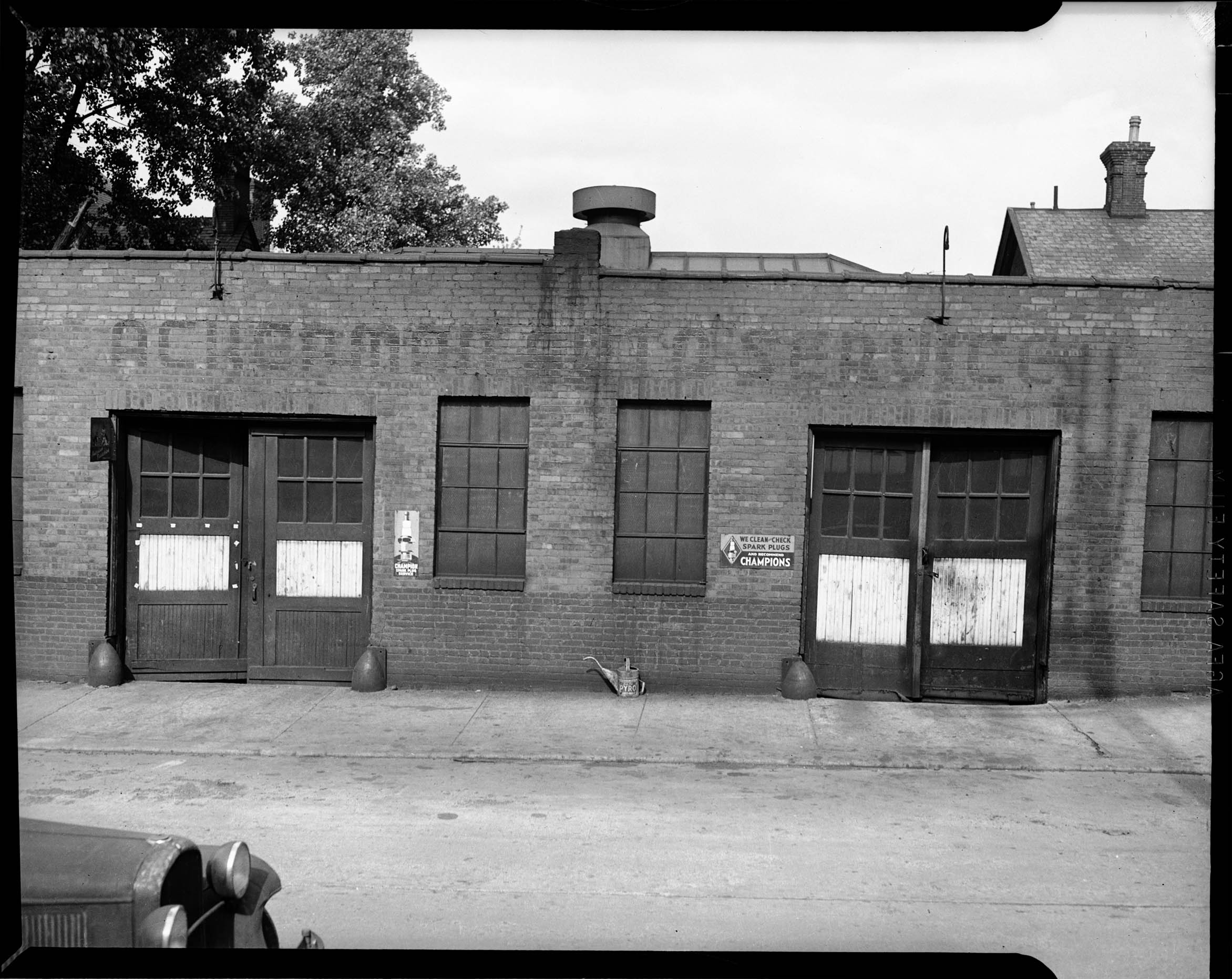 Garage with faded Ackerman Auto Service sign, with two wooden doors