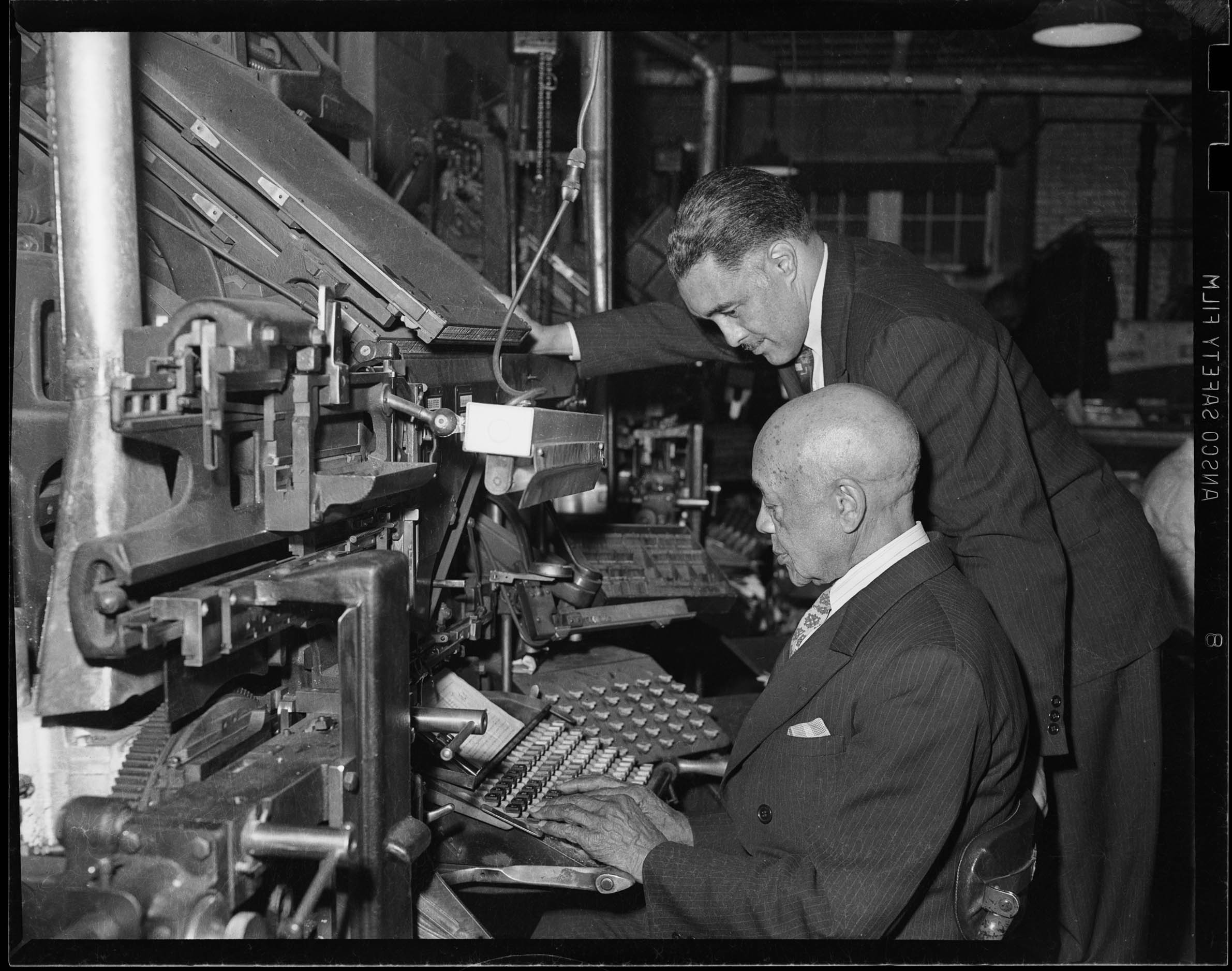 Cornelius Edwards operating typewriter or other keyboard, with Earl V