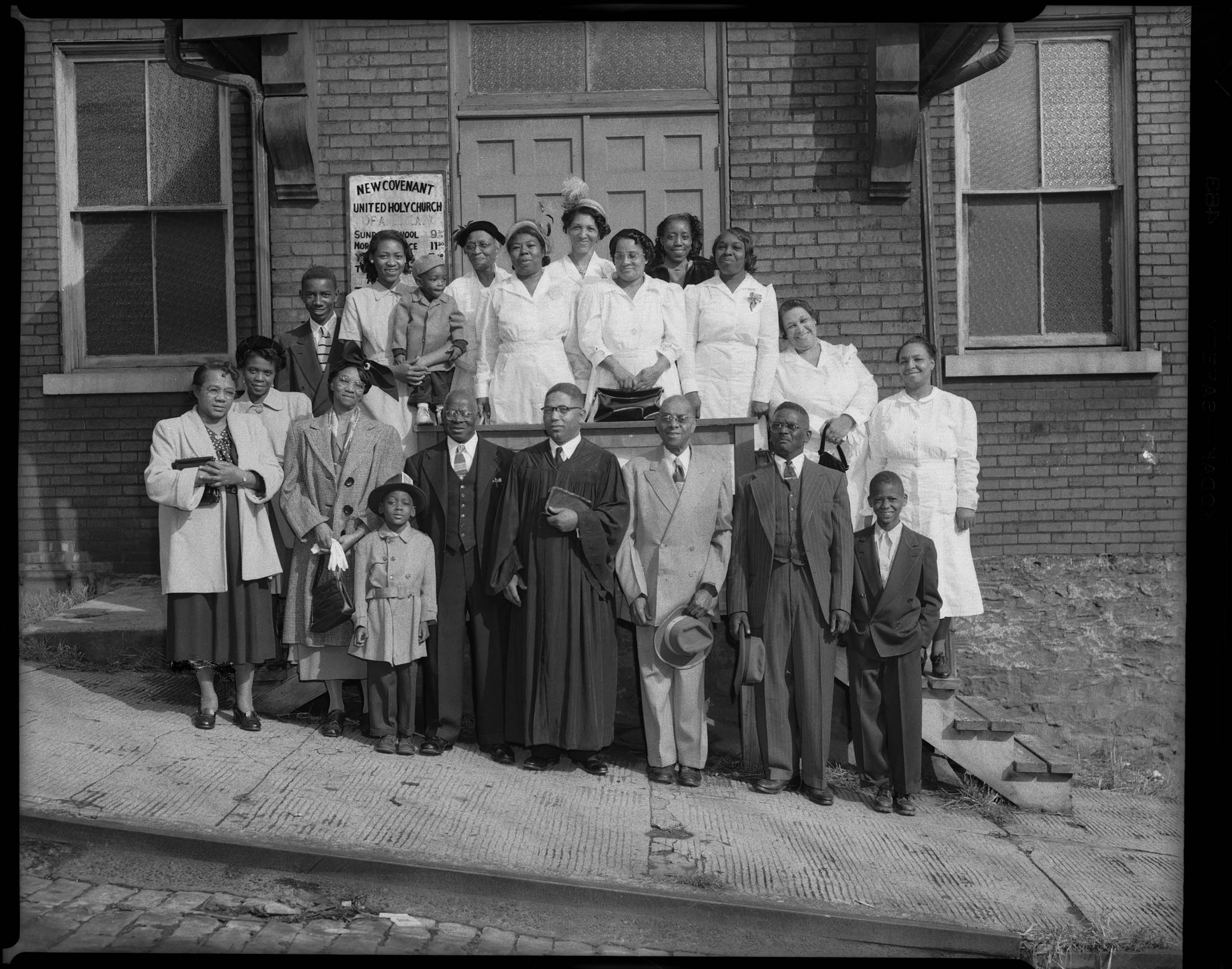 Elder W. J. Jerry standing with women and men of congregation, in front