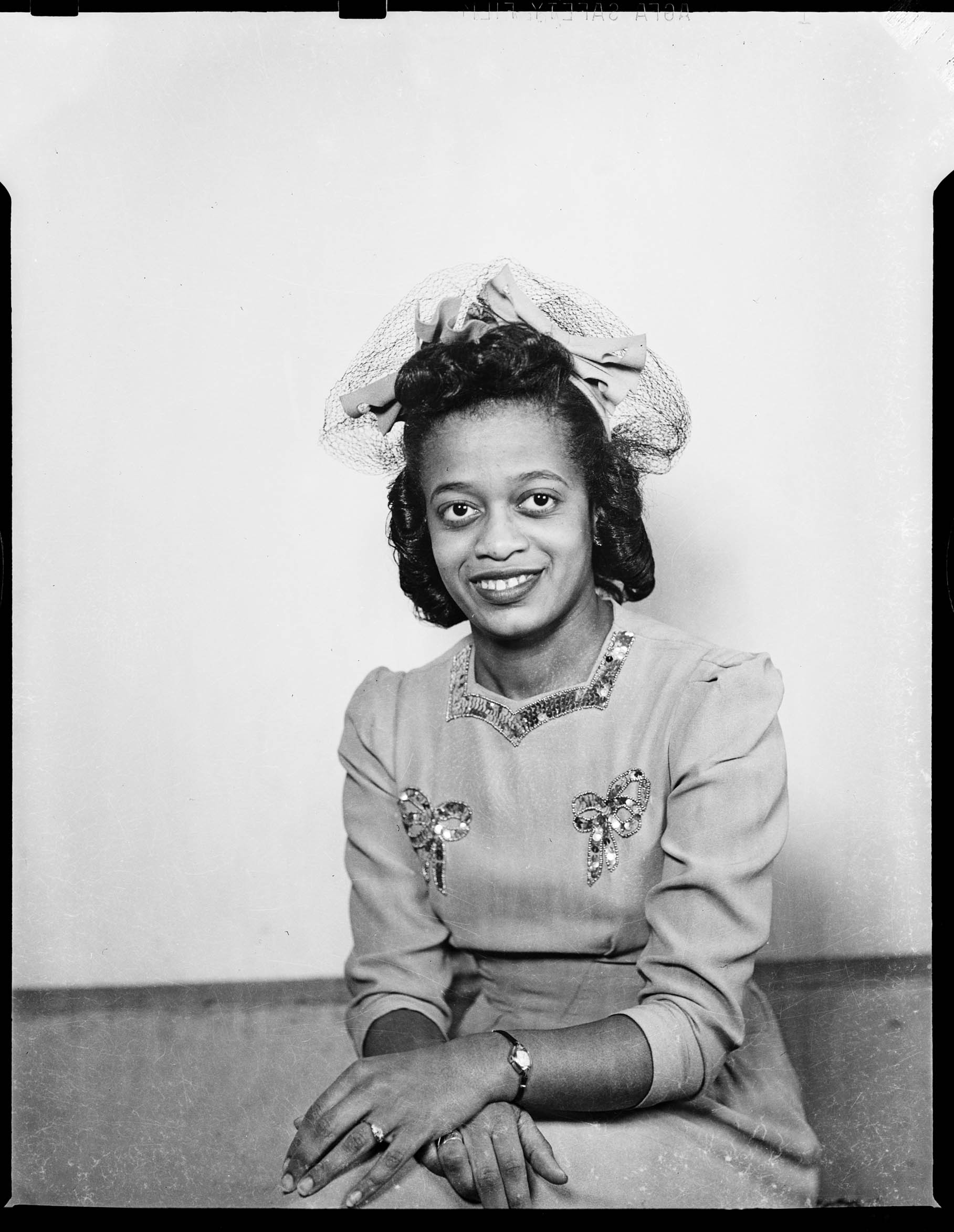 Portrait Of Woman Wearing Solid Colored Dress With Sequined Bows 