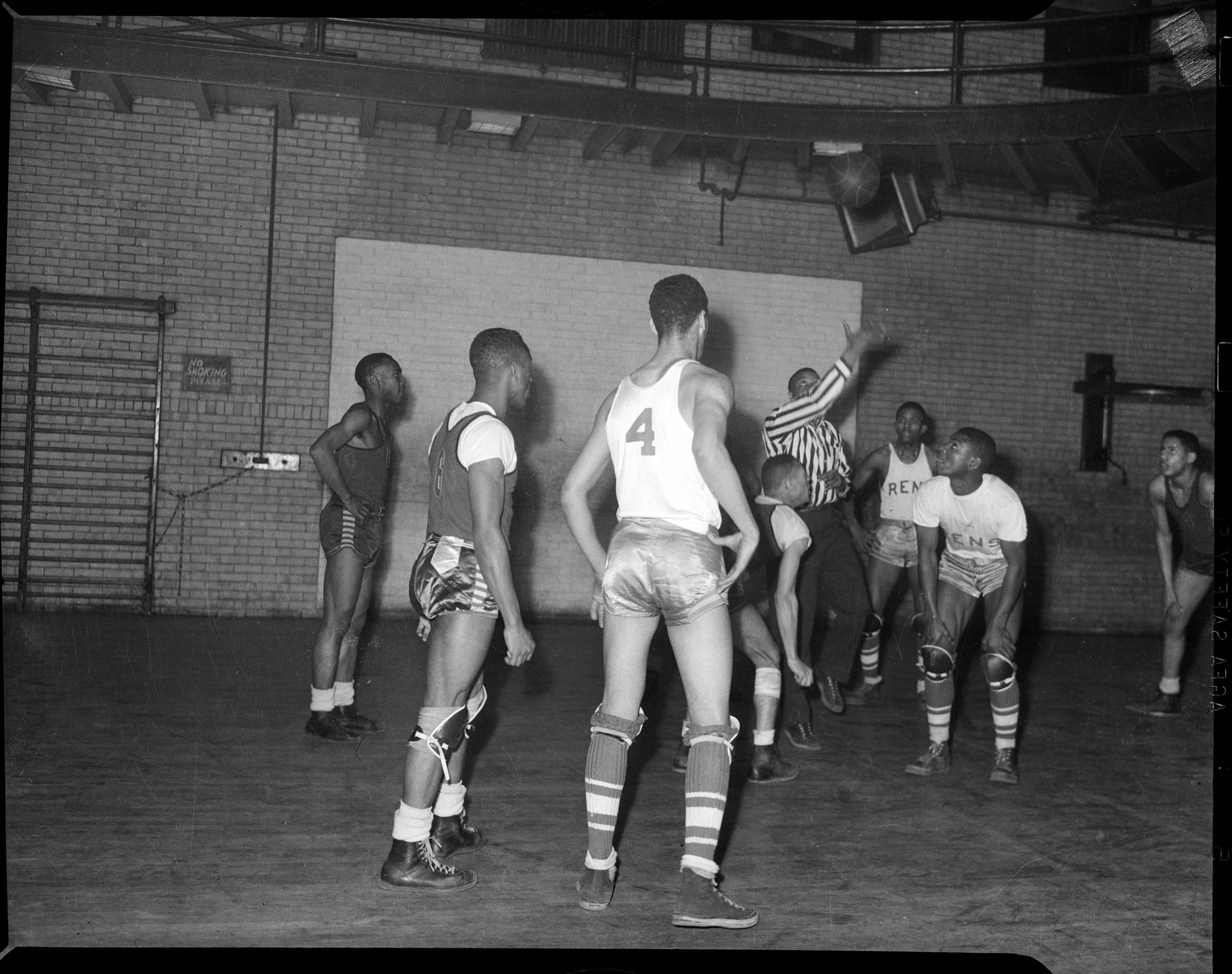 Referee throwing basketball in air, for game between Centre Avenue YMCA