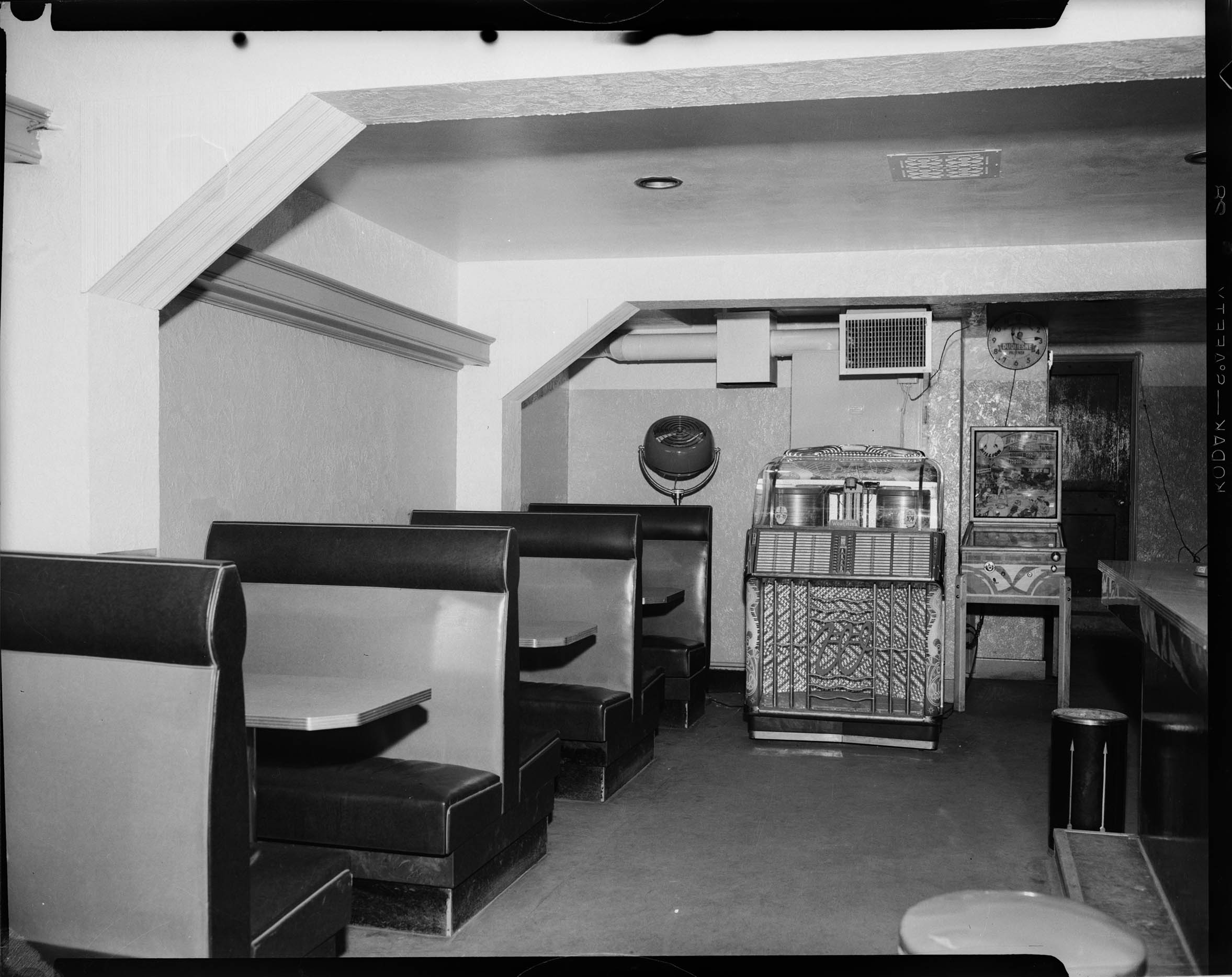 Restaurant with three booths with two toned covering, jukebox, pinball