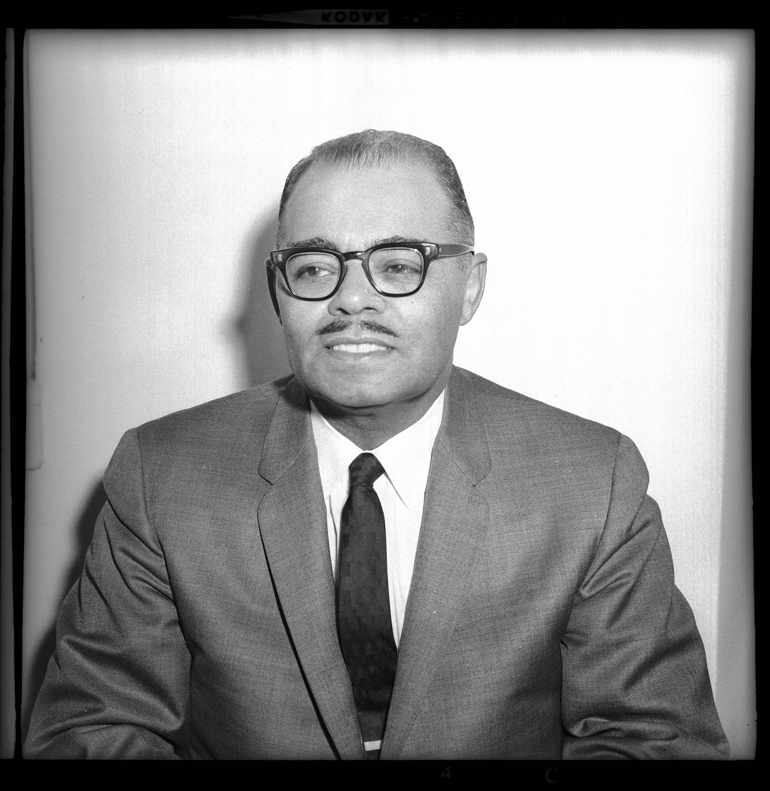 Portrait of Frank Lavelle posed in front of light colored wall
