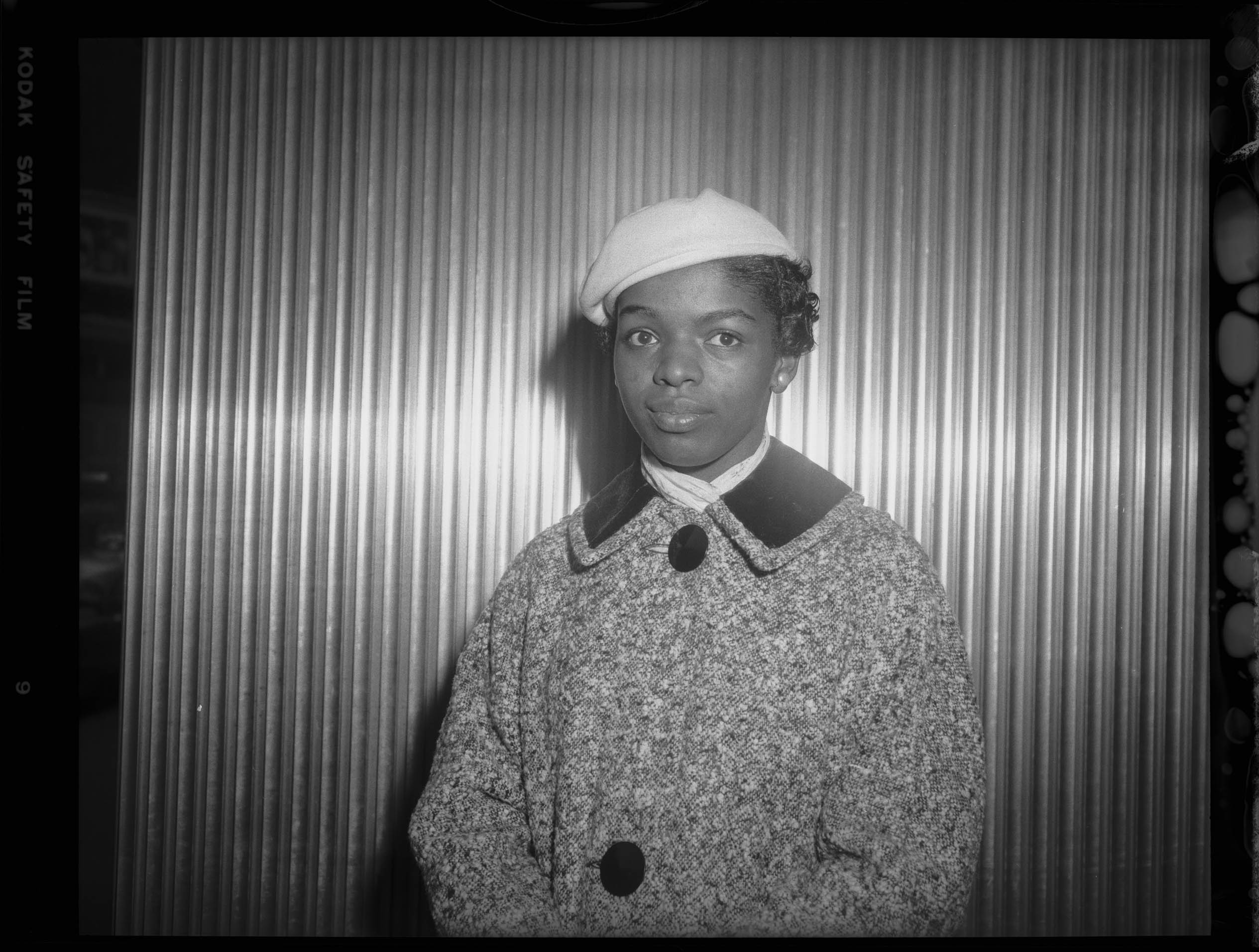 Portrait of Joyce Ingram wearing light colored beret, light colored scarf, and tweed jacket with